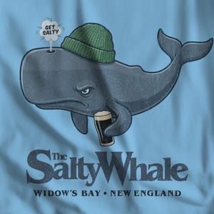 May include: A light blue t-shirt featuring a cartoon whale wearing a green beanie and holding a pint of dark beer. The whale has an angry expression and a speech bubble that says "Get Salty". The text "The Salty Whale" and "Widow's Bay • New England" are below the whale.