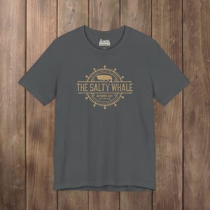 Asphalt gray The Salty Whale vintage distressed pub logo t-shirt inspired by Widow's Bay Apple TV series, soft Bella+Canvas cotton tee