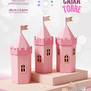 Op de afbeelding: Drie roze papieren kasteeltorens met zeshoekige voet, gekanteelde toppen en boogramen. Elke toren heeft een klein vlaggetje aan de top. De tekst op de afbeelding luidt CAIXA TORRE en MEDIDAS APROXIMADAS 16cm x 6,5cm SEM A BANDEIRINHA.
