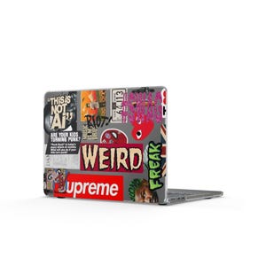 May include: A laptop computer featuring a clear protective case covered in various colorful stickers, including text that reads THIS IS NOT AI, WEIRD, FREAK, and Supreme, alongside graphic images of a red heart, a face, and other assorted designs.