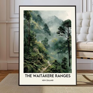 May include: Framed art print featuring a misty forest scene with tall trees and a winding path. The artwork is dominated by shades of green and gray, with the text "THE WAITĀKERE RANGES NEW ZEALAND" at the bottom.