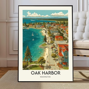 Op de afbeelding: Een ingelijste verticale wandkunstprint met een kustplaatsje met een blauwe baai, zeilboten en een zandstrand. De stad bevat gebouwen met rode daken en groene bomen. De tekst OAK HARBOR WASHINGTON staat onderaan de print afgedrukt.
