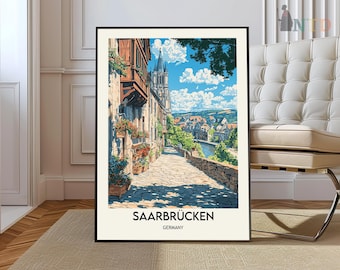 May include: A framed art print featuring a picturesque street scene in Saarbrücken, Germany. The artwork depicts a cobblestone street lined with buildings, flowers, and a distant church. The sky is blue with fluffy clouds. The text "SAARBRÜCKEN GERMANY" is at the bottom.