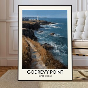 Pode incluir: Uma impressão emoldurada de Godrevy Point, Reino Unido. A obra de arte retrata uma paisagem costeira com um farol, um caminho e o mar. A paleta de cores inclui azuis, castanhos e brancos.