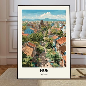 May include: A framed art print featuring a colorful illustration of Hue, Vietnam. The artwork depicts a cityscape with buildings, trees, and a blue sky with clouds. The text "HUE VIETNAM" is printed at the bottom of the print.
