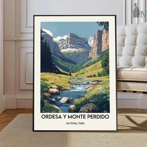 Puede incluir: Una impresión artística enmarcada que presenta un paisaje de valle de montaña con un río. La obra de arte muestra una paleta de colores vibrantes de verdes, azules y marrones, con el texto "ORDESA Y MONTE PERDIDO NATIONAL PARK" en la parte inferior.
