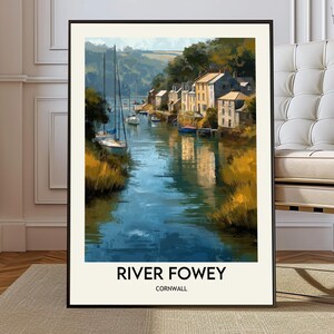 Pode incluir: Uma impressão artística emoldurada do rio Fowey na Cornualha. A obra de arte retrata uma cena fluvial serena com barcos, edifícios e vegetação exuberante. A água reflete o céu e os edifícios. O texto "RIVER FOWEY CORNWALL" está na parte inferior.
