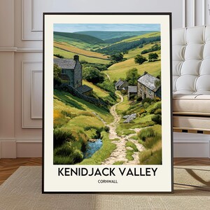 Pode incluir: Impressão artística emoldurada do Vale de Kenidjack, Cornualha. A pintura da paisagem retrata um vale com casas de pedra, um caminho sinuoso e um riacho. A obra apresenta campos verdes e amarelos, com o texto "KENIDJACK VALLEY CORNWALL" na parte inferior.