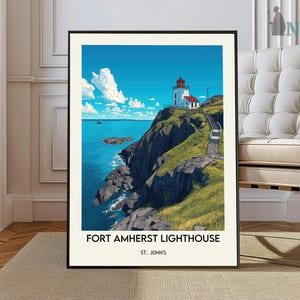 Könnte beinhalten: Ein gerahmter Druck des Fort Amherst Lighthouse in St. John's. Das Kunstwerk zeigt einen weißen Leuchtturm mit rotem Dach auf einer grünen Klippe, mit Blick auf einen blauen Ozean unter einem hellblauen Himmel mit weißen Wolken. Der Druck hat einen schwarzen Rahmen.