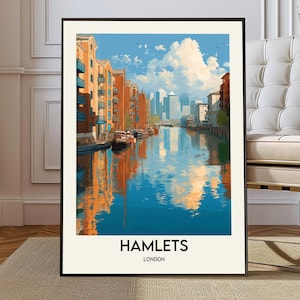 Puede incluir: Una impresión artística enmarcada que muestra una vista de Hamlets, Londres. La obra representa un canal con edificios y barcos, reflejados en el agua bajo un cielo azul con nubes. La impresión tiene un marco negro y el texto "HAMLETS LONDON" en la parte inferior.
