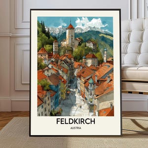 May include: A framed print depicting Feldkirch, Austria, in a watercolour style. The image shows a European town with buildings, red-tiled roofs, a central street, and mountains. The text "FELDKIRCH AUSTRIA" is at the bottom of the print.