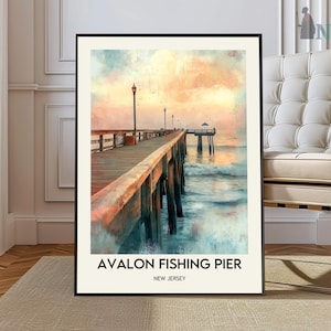 Puede incluir: Una impresión enmarcada del muelle de pesca de Avalon en Nueva Jersey. La obra de arte representa un muelle de madera que se extiende hacia el océano, con un cielo y agua coloridos. El texto "Avalon Fishing Pier" y "New Jersey" está impreso en la parte inferior.