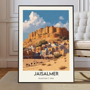 May include: Framed art print of Jaisalmer, Rajasthan, India. The artwork depicts a golden fort atop a hill, with a town below and camels in the foreground. The sky is blue with white clouds. The text "JAISALMER" and "RAJASTHAN | INDIA" are at the bottom.