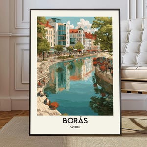 Könnte beinhalten: Ein gerahmter Kunstdruck mit einer malerischen Ansicht von Borås, Schweden. Das Kunstwerk zeigt eine Flussszene mit Gebäuden, Bäumen und Menschen. Der Druck hat einen schwarzen Rahmen und den Text "BORÅS SCHWEDEN" am unteren Rand.