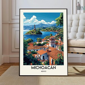 May include: A framed art print of Michoacán, Mexico, featuring a vibrant coastal scene. The artwork depicts a town with red-tiled roofs, a church tower, and a small island with a statue, all set against a blue lake and sky.