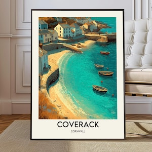 May include: A framed art print of Coverack, Cornwall. The artwork depicts a coastal scene with white buildings, a sandy beach, and turquoise water. Several small boats are in the water. The text "COVERACK CORNWALL" is at the bottom.