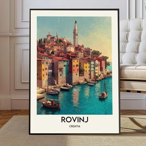 May include: A framed art print of Rovinj, Croatia, featuring colorful buildings along the coast. The artwork depicts a coastal town with boats in the turquoise water. The print includes the text "ROVINJ" and "CROATIA".