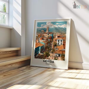 K&ouml;nnte beinhalten: Ein gerahmter Kunstdruck von M&eacute;rida, Venezuela, mit einer farbenfrohen Stadtlandschaft mit roten Ziegeld&auml;chern, blauen Geb&auml;uden und Palmen. Das Kunstwerk enth&auml;lt den Text "M&eacute;rida, Venezuela" am unteren Rand, mit einer Bergkette im Hintergrund.