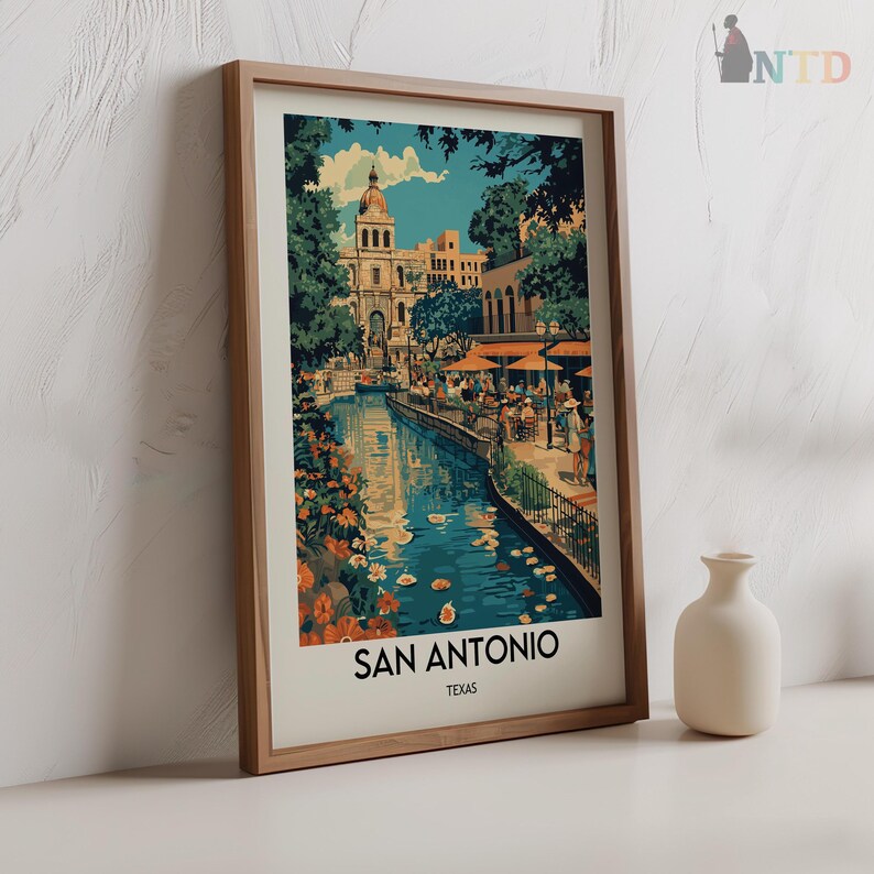 May include: A vintage-style poster with a colorful illustration of a riverfront scene in San Antonio, Texas. The poster features a church building, a river with boats, and people walking along the riverbank. The text "San Antonio, Texas" is printed at the bottom of the poster.
