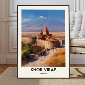 Puede incluir: Una impresión artística enmarcada de Khor Virap, Armenia, que presenta una pintura de acuarela de un monasterio con tejados de tejas rojas contra un fondo de una montaña y un cielo azul. La impresión incluye el texto "KHOR VIRAP" y "ARMENIA".