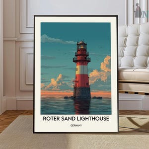 May include: A framed art print of the Roter Sand Lighthouse in Germany. The lighthouse is red and white, standing on a stone base in the sea. The sky is a mix of blue and orange, with fluffy clouds. The print has the text "ROTER SAND LIGHTHOUSE GERMANY".