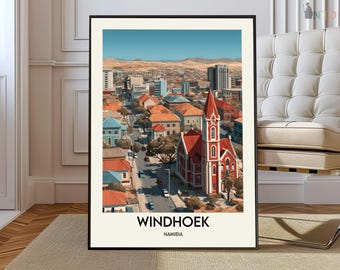 May include: A framed art print featuring a cityscape of Windhoek, Namibia. The image showcases a red-roofed church with a tall steeple, surrounded by buildings and a clear blue sky. The text "WINDHOEK NAMIBIA" is printed at the bottom.