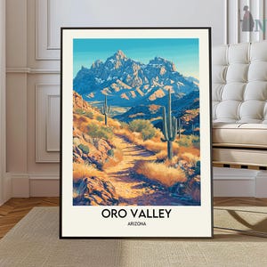 May include: A vintage-style poster featuring a scenic view of Oro Valley, Arizona. The poster depicts a mountain range with a winding path leading through a desert landscape with cacti and brush. The text "Oro Valley, Arizona" is printed at the bottom of the poster.