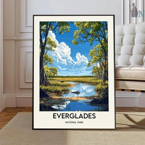 Op de afbeelding: Een vintage poster met een schilderachtig uitzicht op het Everglades National Park. De poster toont een blauwe lucht met witte wolken, weelderige groene bomen en een rustige rivier die door het landschap stroomt. De tekst "Everglades National Park" is in zwart gedrukt aan de onderkant van de poster.