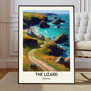 Puede incluir: Un cuadro enmarcado con un paisaje costero con agua turquesa, acantilados y un camino sinuoso. Dos pequeños edificios se encuentran cerca de la orilla. El texto "THE LIZARD CORNWALL" está impreso en la parte inferior.