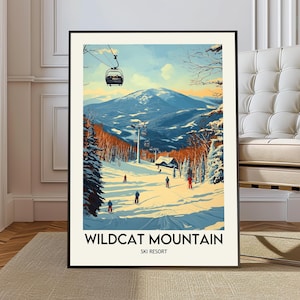 Könnte beinhalten: Ein gerahmter Kunstdruck des Wildcat Mountain Ski Resorts. Das Kunstwerk zeigt eine verschneite Berglandschaft mit Skifahrern, einem Skilift und einer Hütte. Die Farbpalette umfasst Blau-, Weiß- und Orangetöne. Der Text "Wildcat Mountain Ski Resort" befindet sich unten.