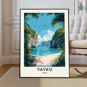 May include: A framed art print showing a tropical beach scene. The artwork depicts a tranquil bay with turquoise water, a sandy beach, and verdant green cliffs. The text "VAVA'U TONGA" is printed at the bottom of the print.