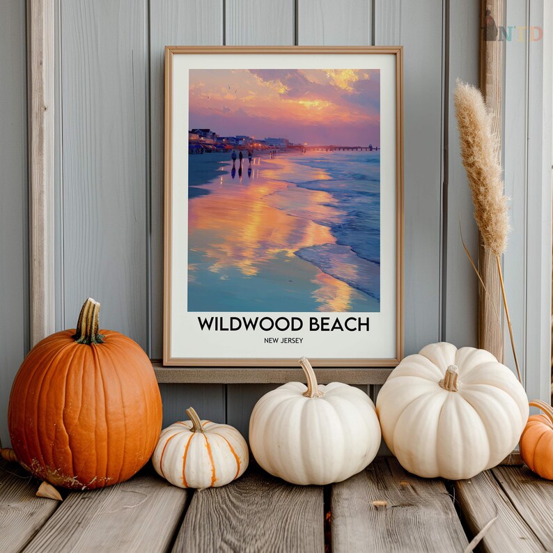 K&ouml;nnte beinhalten: Ein gerahmter Druck von Wildwood Beach, New Jersey, mit einer Sonnenuntergangsszene. Das Bild ist von K&uuml;rbissen in verschiedenen Gr&ouml;&szlig;en und Farben umgeben, darunter orange und wei&szlig;. Die K&uuml;rbisse sind auf einer Holzoberfl&auml;che angeordnet.