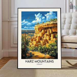 May include: A vintage-style poster with a painting of a mountain landscape with a village built into the side of a cliff. The poster has the text "Harz Mountains, Germany" at the bottom.