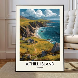 May include: A framed art print of Achill Island, Ireland. The landscape painting depicts a coastal scene with cliffs, a beach, and the ocean under a cloudy sky. The print has a black frame and the text "ACHILL ISLAND IRELAND" at the bottom.