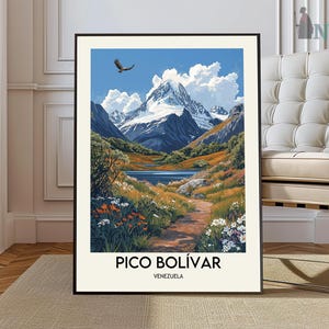 May include: A framed art print featuring a landscape of Pico Bolívar, Venezuela. The artwork depicts a mountain range with snow-capped peaks, a lake, and a path. An eagle soars in the blue sky above. The print has the text "PICO BOLÍVAR" and "VENEZUELA".