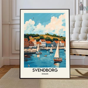 May include: A colorful painting of a harbor scene in Svendborg, Denmark. The painting features a sailboat in the foreground, with colorful buildings and a blue sky in the background. The text "SVENDBORG DENMARK" is printed at the bottom of the painting.