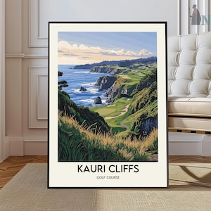 May include: A framed art print of Kauri Cliffs Golf Course. The landscape features a golf course along a coastline with green fairways, cliffs, and the ocean. The sky is blue with clouds. The text "KAURI CLIFFS GOLF COURSE" is at the bottom.