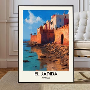 May include: Framed art print featuring a coastal scene of El Jadida, Morocco. The artwork depicts a fortress with orange walls, buildings with white and pink facades, and a turquoise sea under a blue sky with clouds. The text "EL JADIDA MOROCCO" is at the bottom.