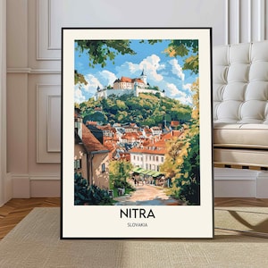 Puede incluir: Una impresión artística enmarcada de Nitra, Eslovaquia, con una ilustración detallada de un paisaje urbano histórico. La obra de arte muestra un castillo en la cima de una colina verde, con edificios de tejados rojos debajo. Incluye el texto "NITRA SLOVAKIA".