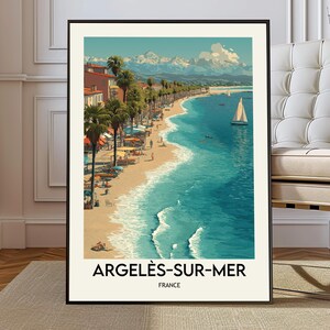 Könnte beinhalten: Ein gerahmter Kunstdruck von Argeles-Sur-Mer, Frankreich. Das Bild zeigt eine Strandszene mit türkisfarbenem Wasser, einem Sandstrand, Palmen und Gebäuden. Ein Segelboot ist auf dem Wasser. Der Text "ARGELES-SUR-MER FRANCE" steht unten.