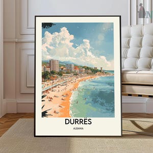 Può includere: Una stampa artistica incorniciata con una scena di spiaggia a Durazzo, Albania. L'opera raffigura una giornata di sole con una spiaggia sabbiosa, acqua turchese ed edifici costieri. La stampa include il testo "DURRËS" e "ALBANIA".