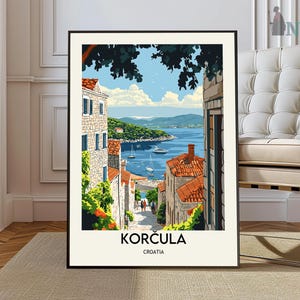 May include: A framed art print featuring a scenic view of Korcula, Croatia. The artwork depicts a coastal town with buildings, red-tiled roofs, and a blue sea with sailboats. The print includes the text "KORČULA" and "CROATIA".