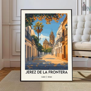 May include: A framed art print of Jerez de la Frontera, Spain, depicting a sunlit street scene with buildings, a church, and a palm tree. The print has a black frame and the text "JEREZ DE LA FRONTERA" and "CADIZ | SPAIN" at the bottom.