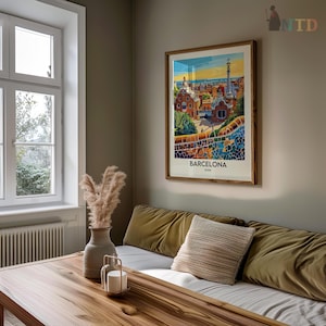 Puede incluir: Un cartel de viaje vintage con una ilustraci&oacute;n colorida de Barcelona, Espa&ntilde;a. El cartel est&aacute; enmarcado en un marco de madera y cuelga en una pared de una sala de estar.