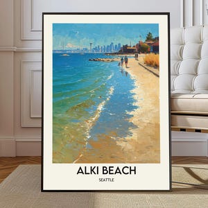 May include: A framed art print of Alki Beach in Seattle. The painting depicts a sunny beach scene with blue water, a sandy shore, and a distant cityscape. The words "Alki Beach" and "Seattle" are printed at the bottom.