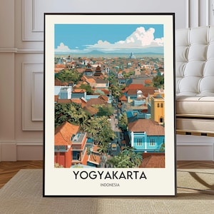 May include: A framed art print featuring a vibrant cityscape of Yogyakarta, Indonesia. The artwork showcases a detailed aerial view of the city with colorful buildings, lush greenery, and a bright blue sky. The text "YOGYAKARTA INDONESIA" is displayed at the bottom.
