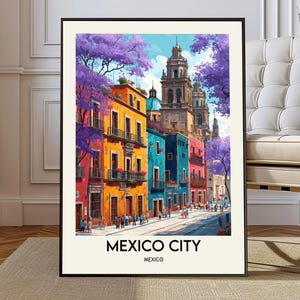 Può includere: Una stampa artistica incorniciata di Città del Messico. L'opera raffigura edifici colorati nei toni del rosso, arancione, blu e rosa, con alberi fioriti viola. Il testo "MEXICO CITY" e "MEXICO" è stampato in basso.