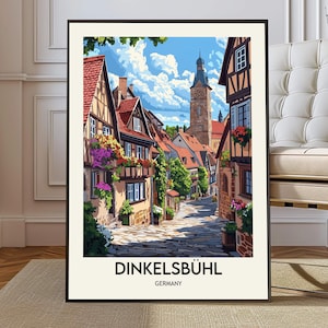 May include: A framed print of Dinkelsbühl, Germany, featuring a colorful illustration of a European town. The artwork showcases cobblestone streets, half-timbered buildings with red tile roofs, and a tall church tower under a blue sky.