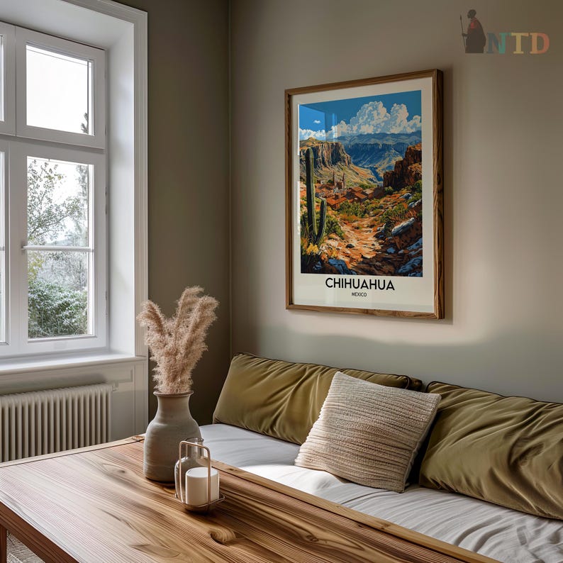 Peut inclure: Une affiche encadr&eacute;e pour Chihuahua, Mexique, est accroch&eacute;e au mur au-dessus d'un canap&eacute;. L'affiche pr&eacute;sente une vue panoramique d'un canyon avec un sentier, des cactus et des montagnes. La pi&egrave;ce comprend &eacute;galement une table en bois, un vase avec des plantes s&eacute;ch&eacute;es et un bougeoir d&eacute;coratif.