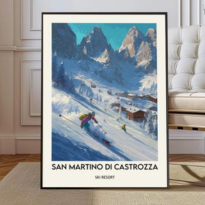 Op de afbeelding: Een ingelijste kunstdruk van een skigebied. Het kunstwerk toont skiërs op een besneeuwde helling met bergen op de achtergrond. De tekst "SAN MARTINO DI CASTROZZA" en "SKI RESORT" staan onderaan de print.